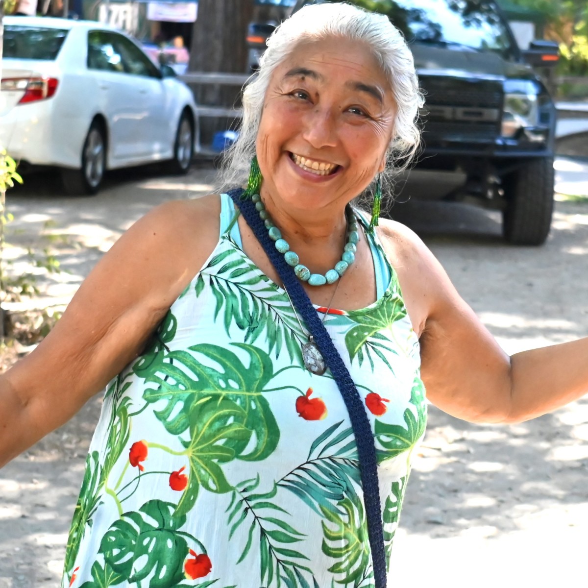 A KZFR volunteer smiling with a lei at the Touch of Chico wellness event.